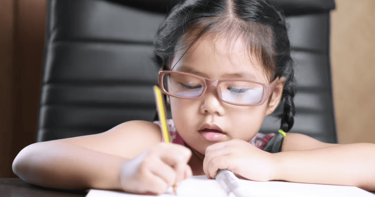 Cúi sát khi học tập là một trong các biểu hiện của cận thị ở trẻ em