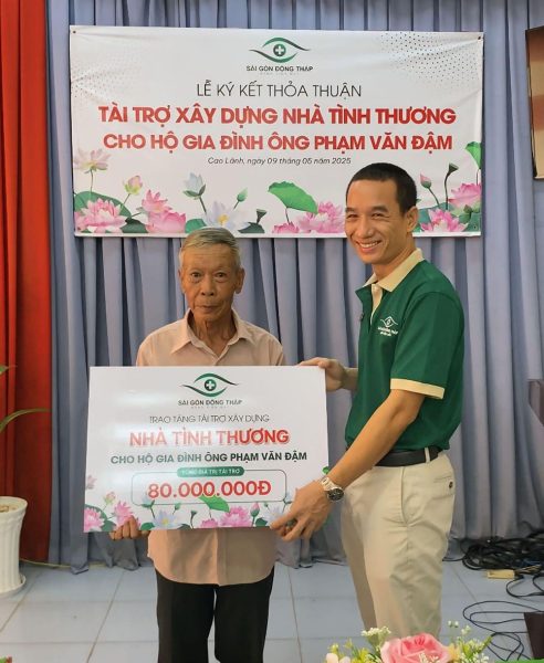 Ông Nguyễn Văn Thêm, Chủ tịch kiêm Giám đốc Bệnh viện Mắt Sài Gòn Đồng Tháp, trao khoản hỗ trợ 80 triệu đồng cho bà Nga, đại diện gia đình.